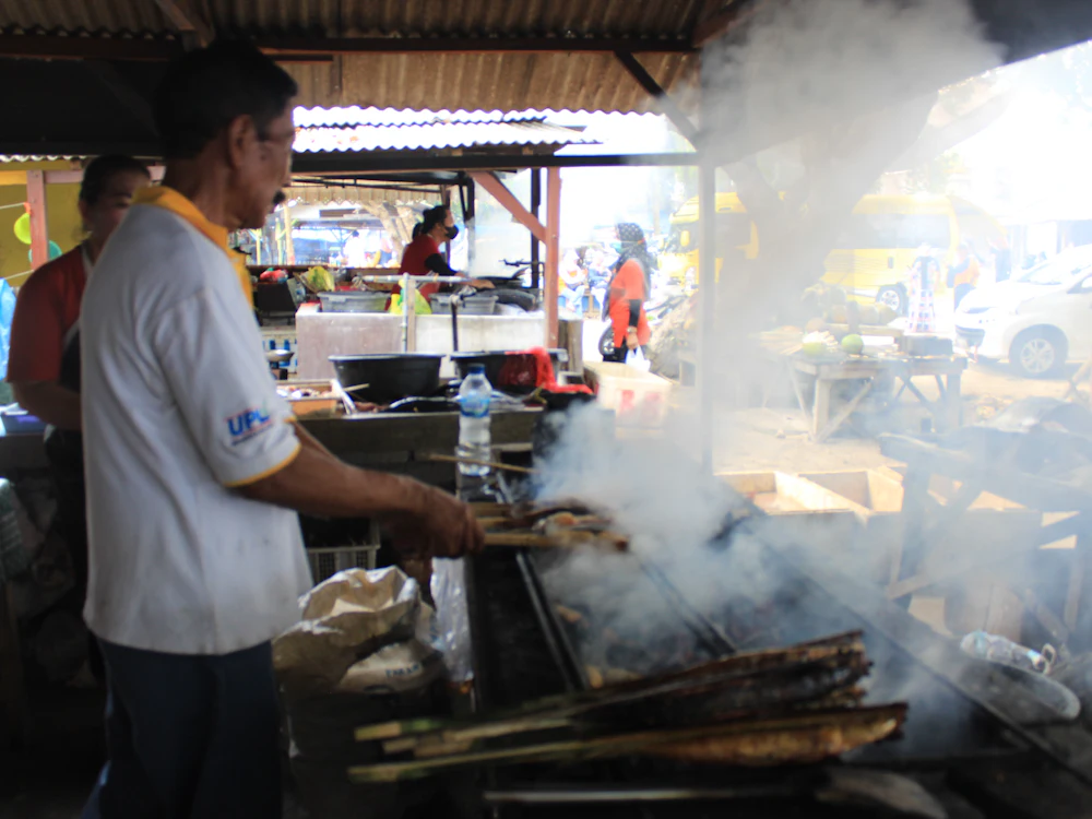 Tukang masak sedang membakar satay